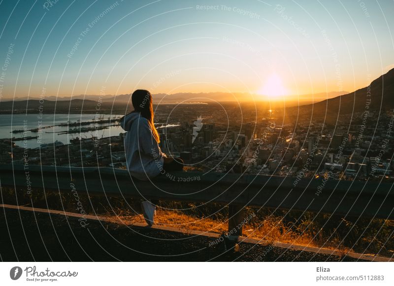 Woman sitting on guardrail watching sunrise over Cape Town Sunrise in the morning Trip Sunlight Human being Freedom mountains atmospheric travel Lonely