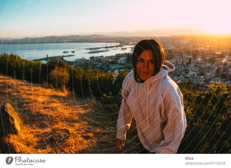 Portrait of a young woman in a gray hoodie in the light of the rising sun Woman youthful Hill Cape Town Hooded sweater Hoodie South Africa Sun morning sun