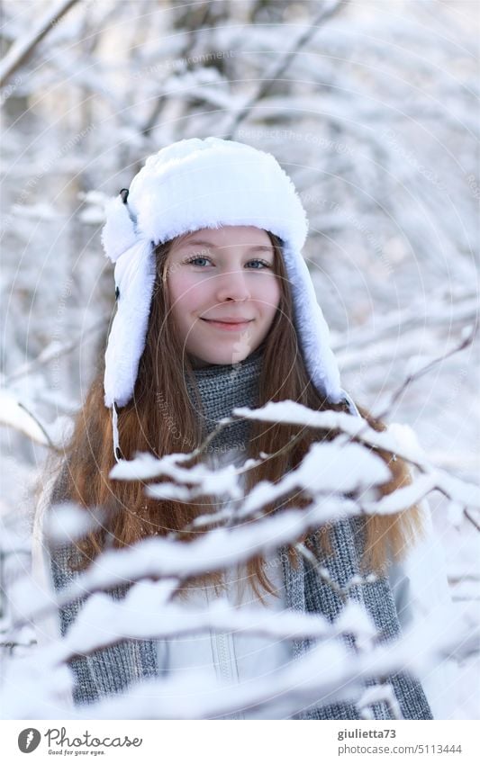 Portrait of long haired teenage girl with Russian ushanka cap in snowy park portrait Girl Portrait of a young girl Young woman Girlish Long-haired Winter Cap