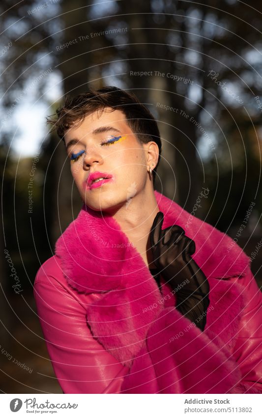 Transsexual guy with makeup standing in park with closed eyes man transsexual forest eyes closed touch neck lgbt androgynous style autumn homosexual transgender