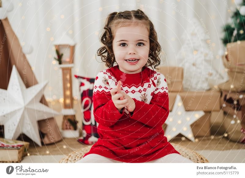 smiling little girl at home during christmas time child presents happy gift cheerful cute 2 kid children family december decoration indoors smile adorable star