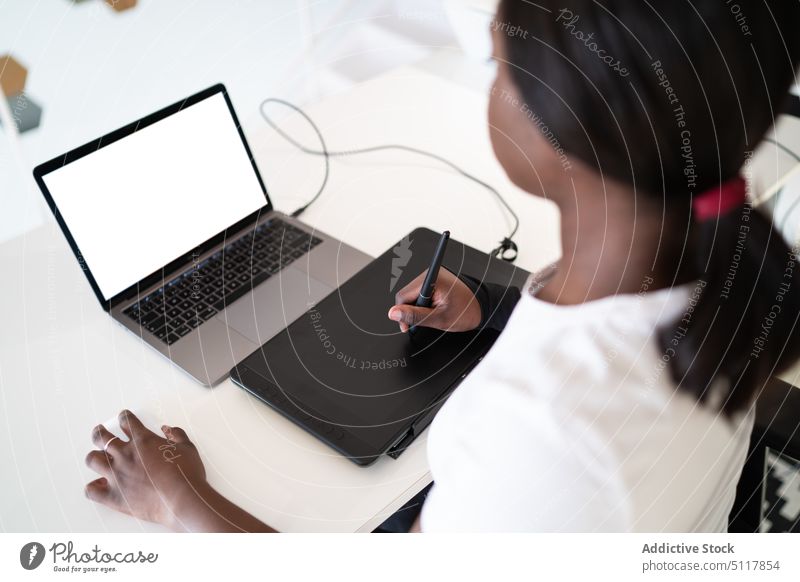 Black illustrator drawing on graphic tablet woman laptop using creative blank screen home office project female black african american ethnic freelance create