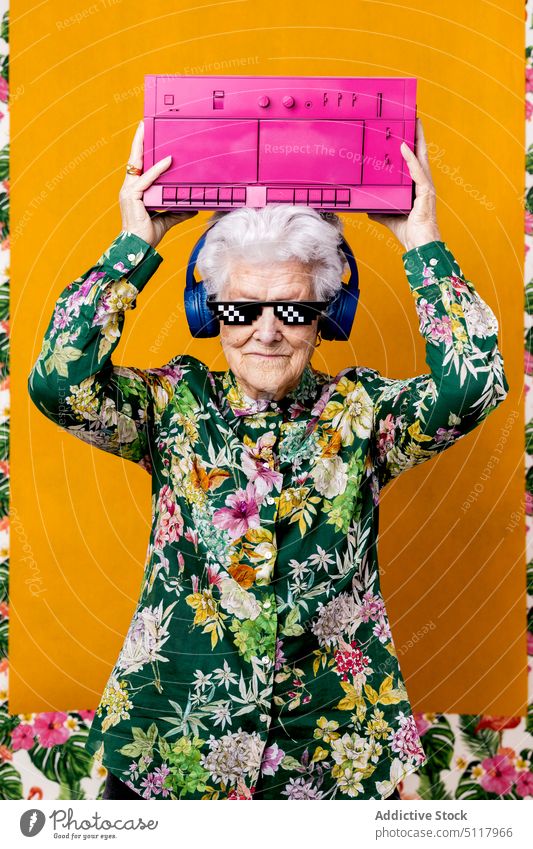 Cool elderly meloman with boombox mockup on face woman cool listen music carry colorful bright female senior aged retire pensioner headphones wireless player