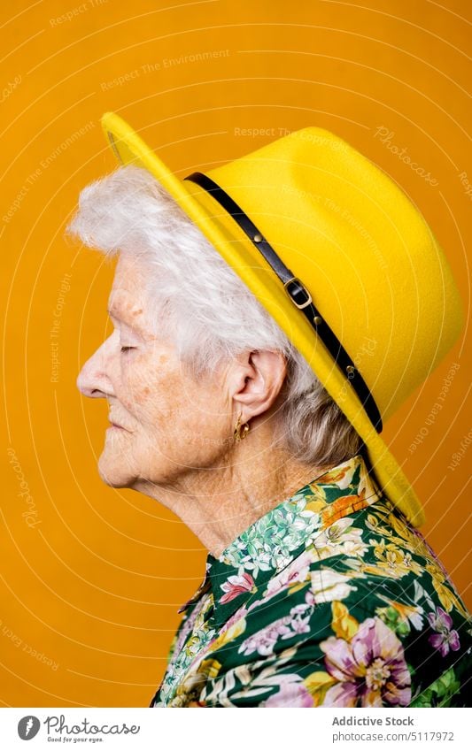 Calm female pensioner in stylish hat woman calm style shirt personality appearance portrait colorful bright elderly senior aged retire short hair serene