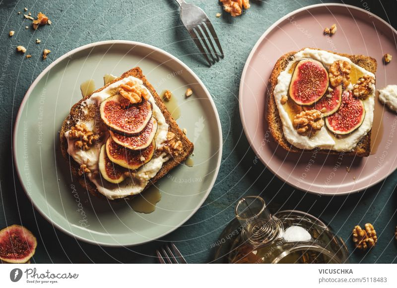 Breakfast french toasts with cream fresh, fig slices and nuts, drenched in maple syrup on plates , top view breakfast toasted fruit table fried honey homemade