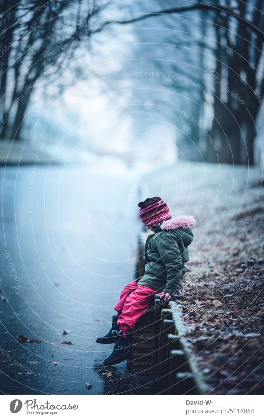 Danger - girl in winter on a frozen river Winter Ice River Lake peril Child collapse Girl inquisitorial danger spot Winter mood Winter's day chill Curiosity
