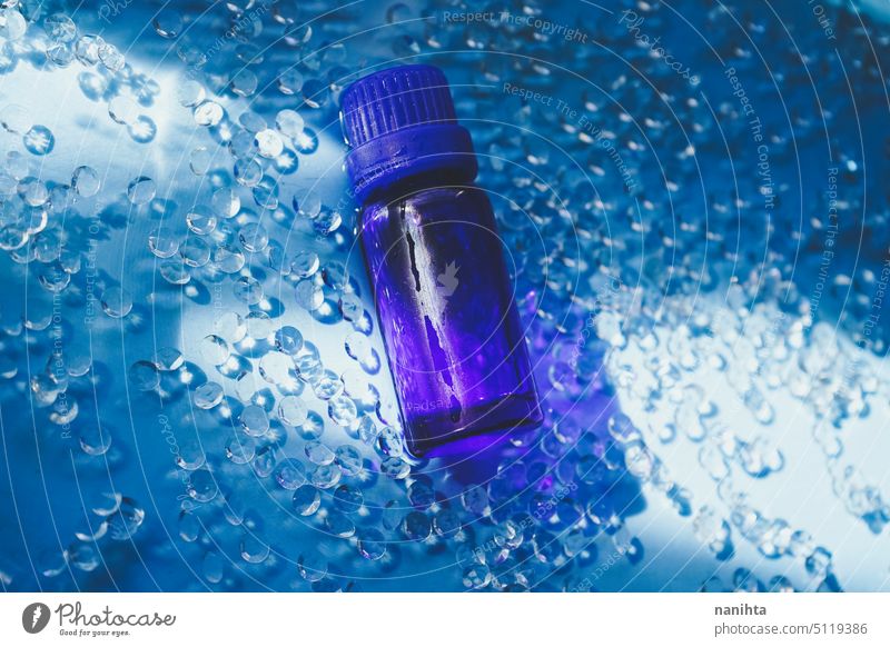 Organic essencial oil in a dark blue bottle against an elegant blue background essential health fresh diamond water still life object product essential oil