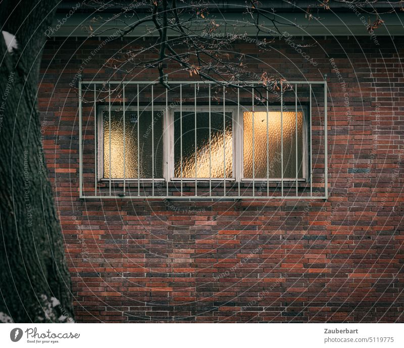 Window grille, window in brick wall, light play in ornamental glass Glass Grating Light Wall (building) Winter urban Manmade structures mystery Mysterious