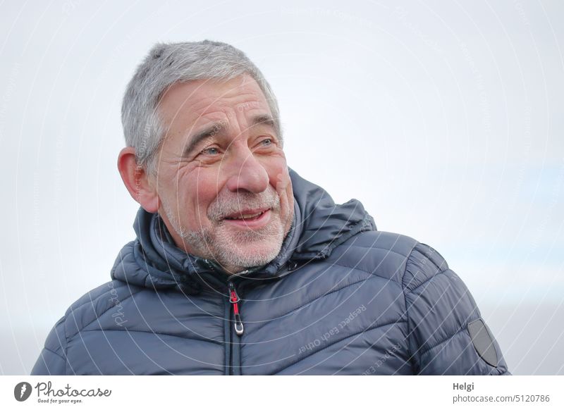 Portrait of senior citizen with short gray hair, three-day beard and mischievous smile Human being Man Senior citizen age portrait Smiling Impish Jacket Winter
