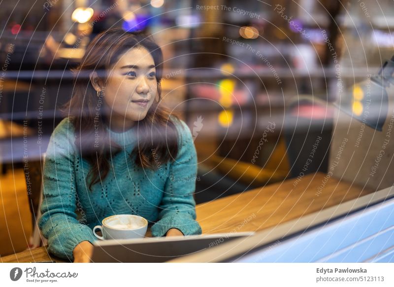 Young woman drinking coffee in cafe real people candid girl young adult fun millennials Millennial Generation asian Japanese happy smiling happiness one person