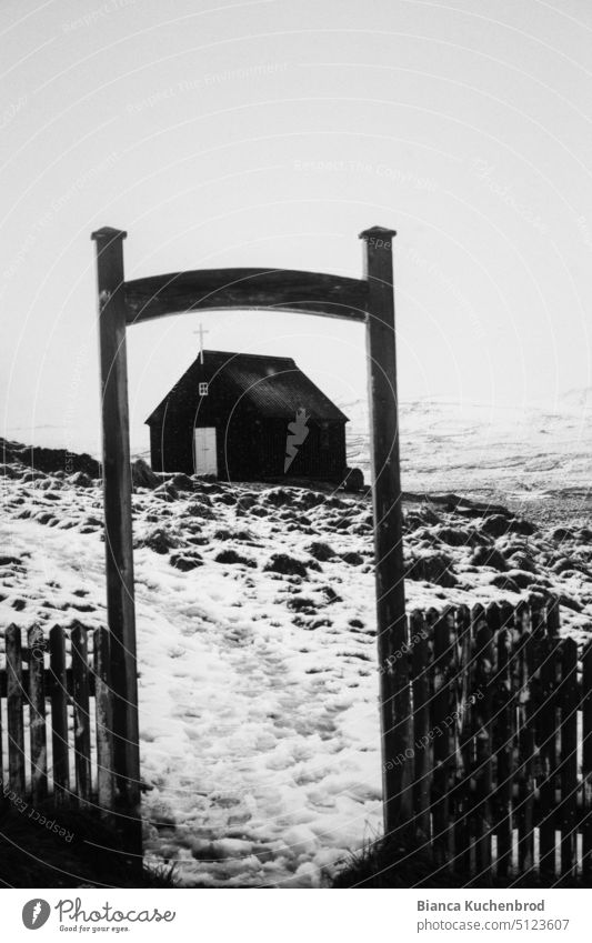Footprints lead through an open frame to a black church in Iceland. Black & white photo Church Exterior shot Day Religion and faith Deserted Vacation & Travel