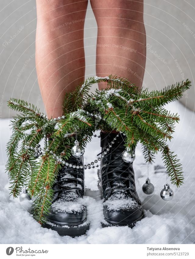 Person legs in heavy boots with Christmas tree branches christmas christmas tree decorated snow winter person snow covered xmas concept chunky bouquet