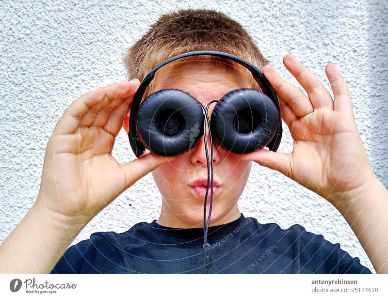 Boy holding up headphones to eyes boy child play glasses fun playing big eyes