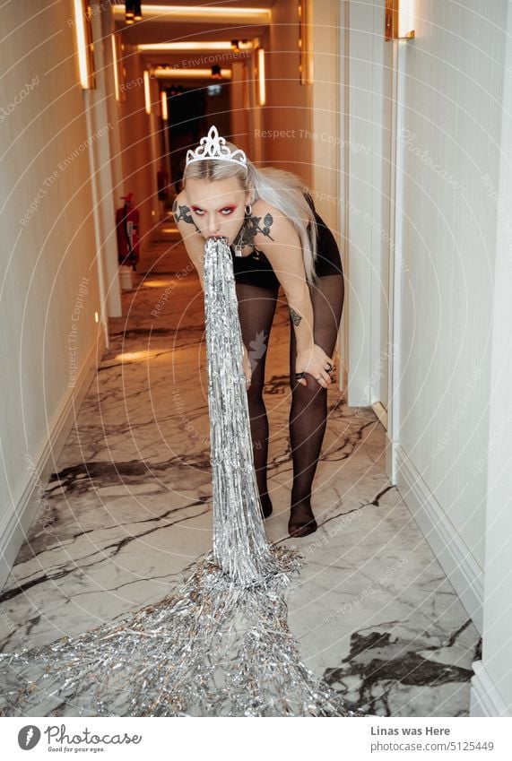 A gorgeous blonde queen with her festive makeup and wild tattoos is getting tired of celebrations. Vomiting glitter confetti in a corridor. It must be a joyous overdose.