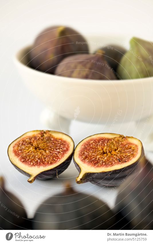 Two fig halves in front of a bowl with figs, Nymphenburg porcelain Figs halved Sliced Fig halves fruit fruits Fruit flesh Sámen Deserted shell Porcelain bowl