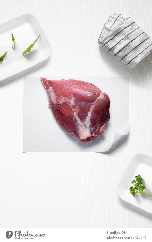 Whole beef steak piece on a kitchen with some herbs whole meat raw butcher shop copy space parsley arugula cook cooking ingredients flat lay still life food