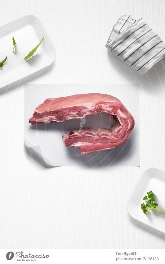 Veal ribs on a kitchen with some herbs veal whole meat piece raw butcher shop copy space parsley arugula cook cooking ingredients flat lay still life food table