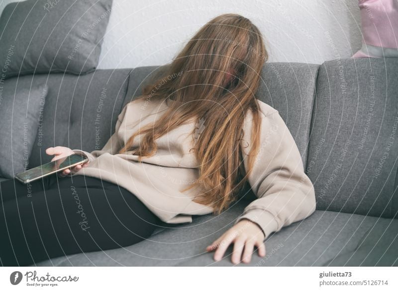 Burnout, young woman lies completely exhausted on the couch, falls asleep with cell phone in hand portrait Woman Young woman teenager Girl 13 - 18 years