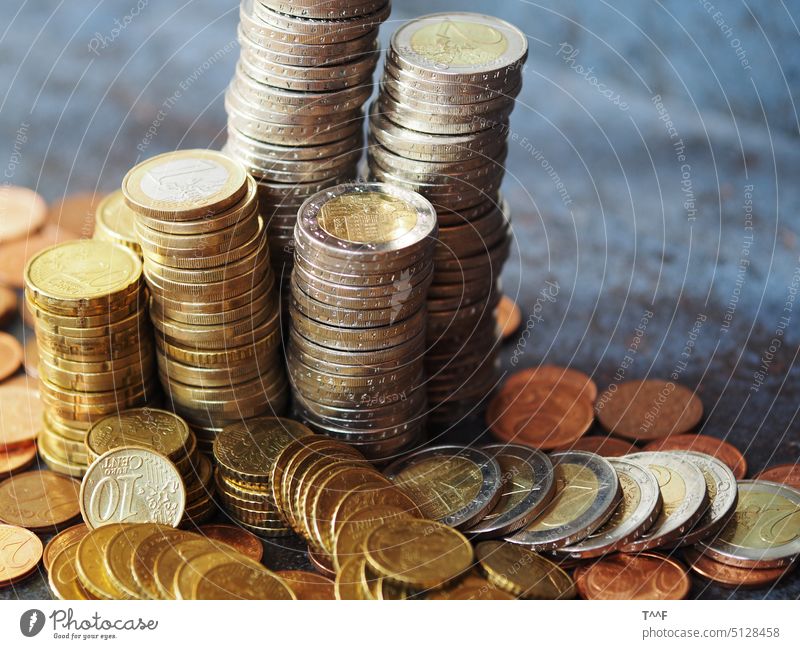 Münztürmchen  – aufgehäufte Euromünzen auf grauschwarzer Fliese mit Rostflecken Geld Eurocent Bezahlung Währung Kleinvieh Kupfer Kupferstücke
