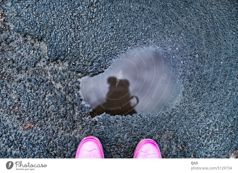 Mirror Mirror ..in the puddle Puddle reflection Rubber boots Pink Asphalt Cap Gray structure Clouds Water Rain streets Bobble hat Winter daylight from on high