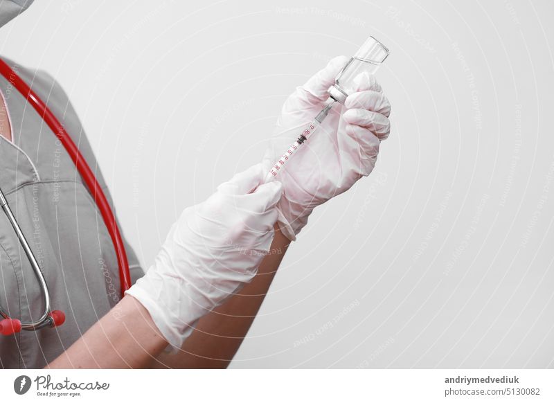 Doctor, nurse or scientist hand in white medical gloves holding flu, measles, coronavirus vaccine shot for diseases outbreak vaccination, medicine and drug concept
