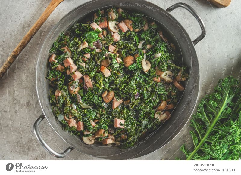 Stewed kale with mushrooms in cooking pot. Healthy green food. Top view stewed healthy top view vegetarian homemade vegan above cabbage diet meal