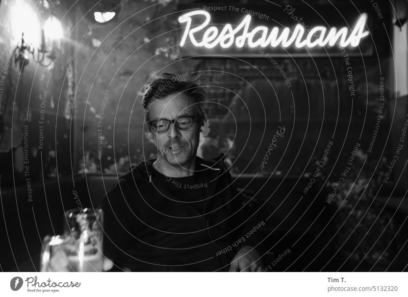 a man with glasses in a pub Berlin Prenzlauer Berg b/w Roadhouse Bar Night Man Eyeglasses Restaurant Town Capital city Downtown Black & white photo