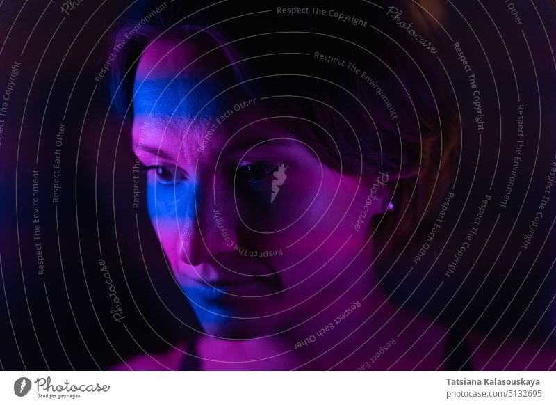 Stripes of blue and purple neon light up the face of a young dark-haired woman Portrait Neon Lighting Neon Colored Illuminated Colors Magenta Pink Color Image