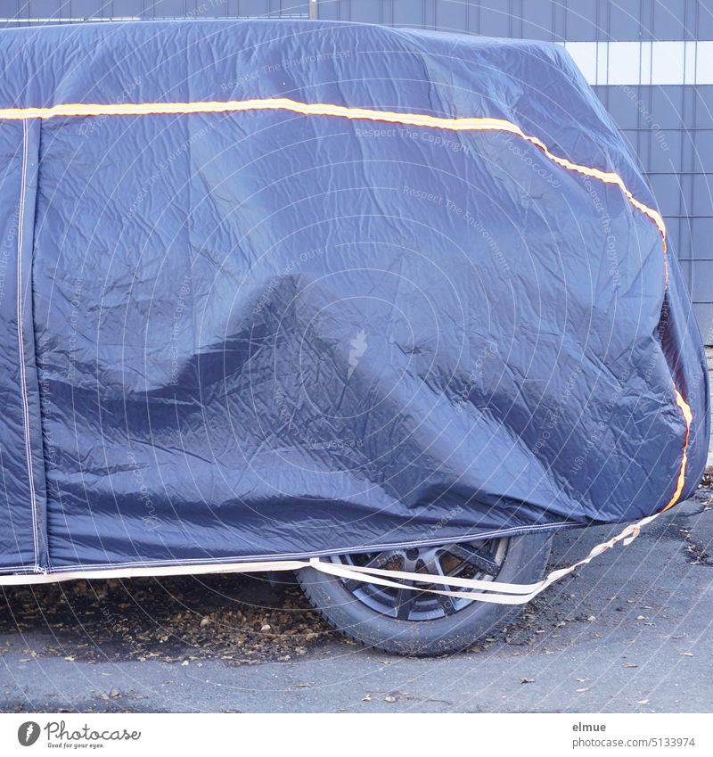 blue plastic tarpaulin over a car on the roadside Car shrouded Protection protective tarpaulin safeguarded Blue Blog Weather protection covert snow protection