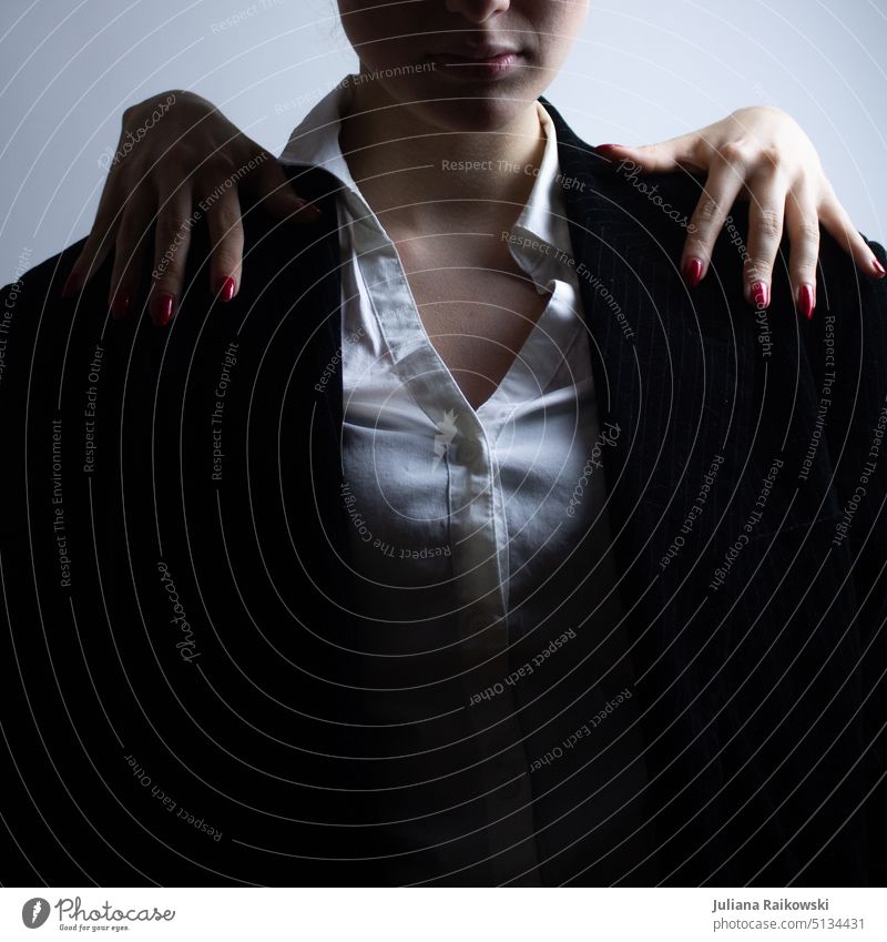 Woman in suit is attacked from behind Dramatic hands Suit Mysterious Strong Artificial light strong woman Contrast portrait Feminine Studio recordings Adults
