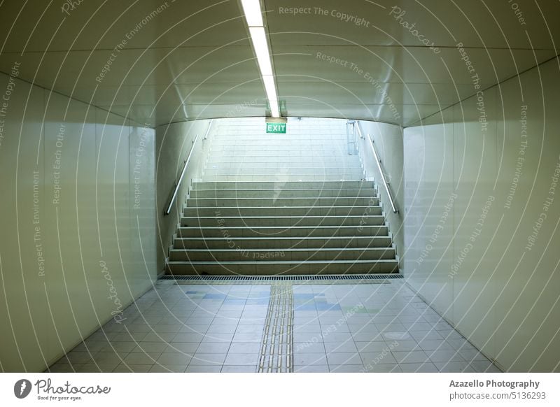 Underground passage with an exit sign over the staircase. aim architecture blank board bright building clean concept construction decision design future goal