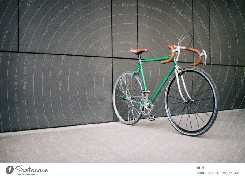 Green vintage racing bike in front of gray wall Racing cycle singlespeed urban Copy Space left Mobility Retro Lifestyle Bicycle Means of transport Athletic