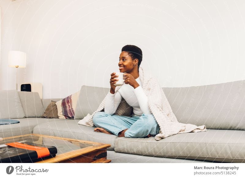 person sitting on a sofa and drinking coffee apartment asian attractive beautiful beverage black break breakfast comfort comfortable copy space couch cozy cup