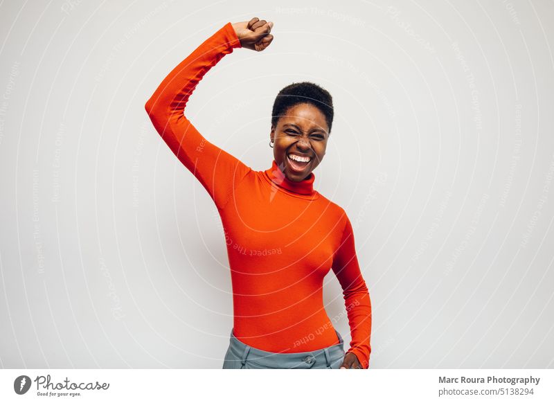 black woman person wearing a red shirt celebrating achieve result african afro american background beautiful casual cheerful customer smile excited