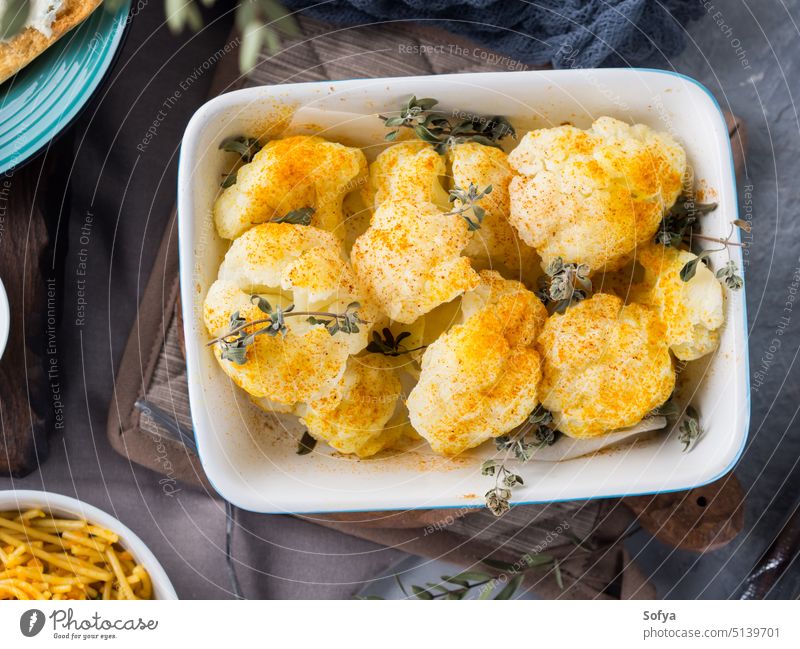 Baked cauliflower with turmeric and marjoram baked herb lunch dinner healthy curry vegetable green cooked tin ceramic bowl serve cuisine spicy recipe dish food