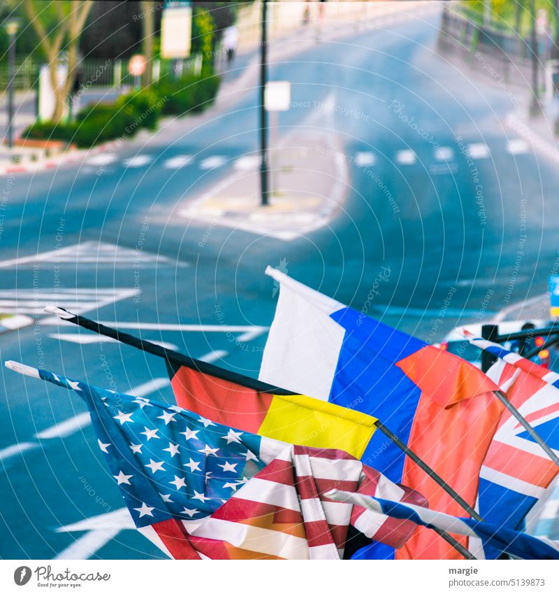 Street with community flags, flags Flag Exterior shot Blue Pedestrian crossing Colour photo Flags characteristics Traffic lane Blow Lane markings