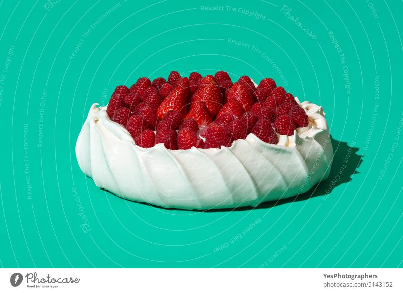Pavlova cake topped with fresh berries, isolated on a green background. australian baked close-up color cream crispy crust cuisine delicious design dessert