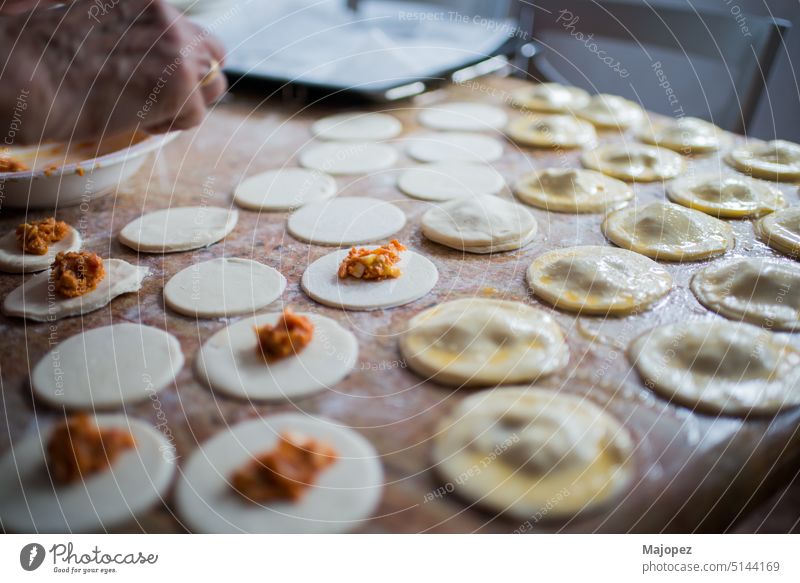 Filling and sealing puff pastry dumplings in a kitchen pattern aged woman appetizer background bowl celebration closeup cooking copy space culture delicious