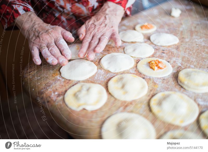 Human hands filling and sealing puff pastry dumplings pattern aged woman appetizer background bowl celebration closeup cooking copy space culture delicious
