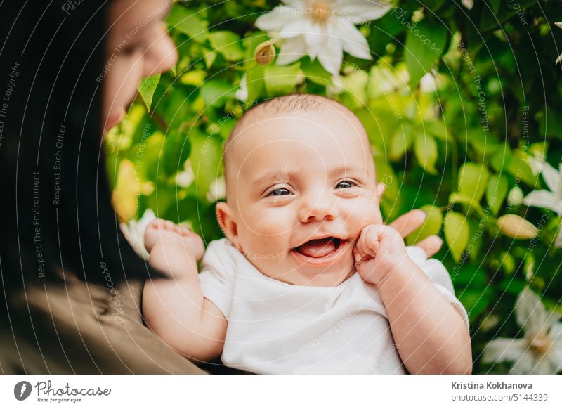 Beautiful portrait of little baby boy on flowers bush background. Child in spring blossom. Cute newborn son smiling. child happy childhood kid caucasian