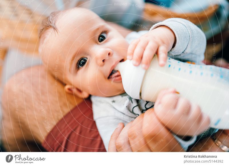 Little baby boy drinking mother milk from the bottle and smiling care caucasian child childhood cute food infant kid little adorable bed feeding girl happy