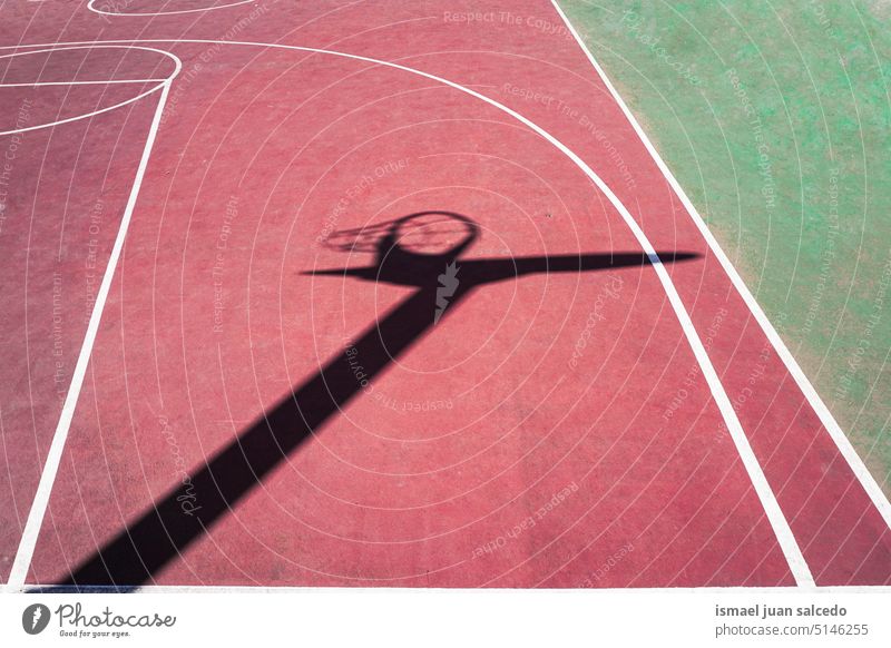 shadow of the basketball hoop on the basketball court street basket net silhouette sunlight ground sports court field sports field floor equipment