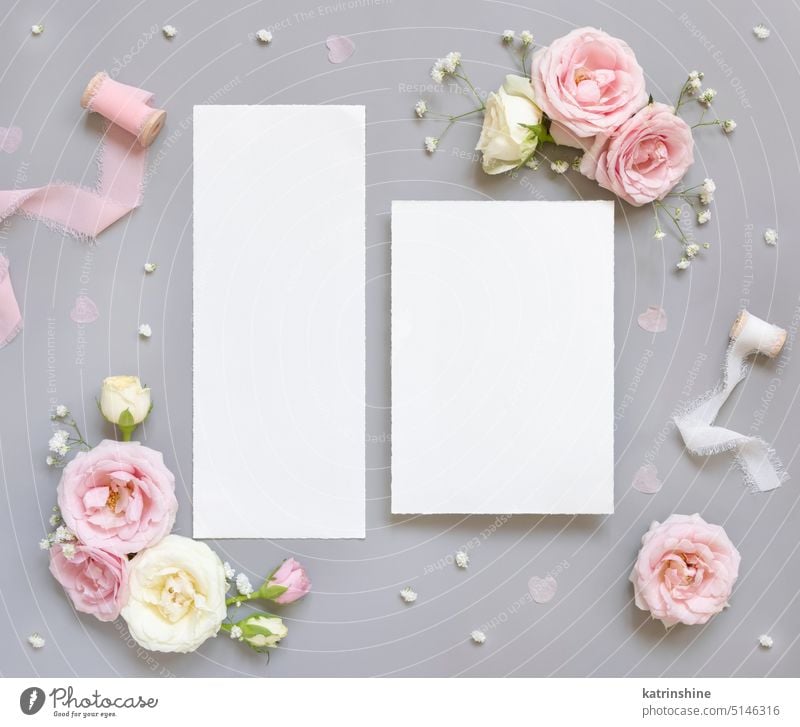 Blank paper cards between pink roses and pink silk ribbons on grey top view, wedding mockup flowers girlish white valentine spring mothers day WEDDING Marriage