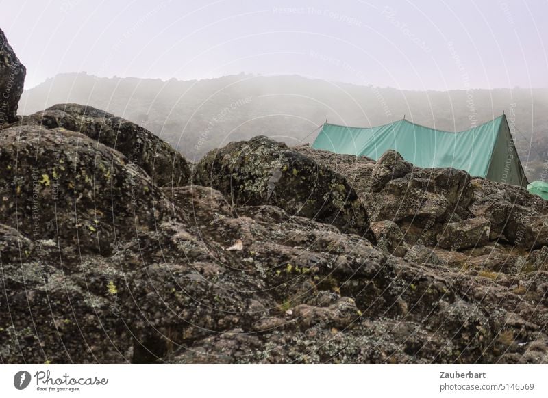Green tent of porters behind boulders in clouds and fog at Kilimanjaro, Shira Camp 2 Tent variegated Rock rock Boulders Fog Clouds Hiking trekking