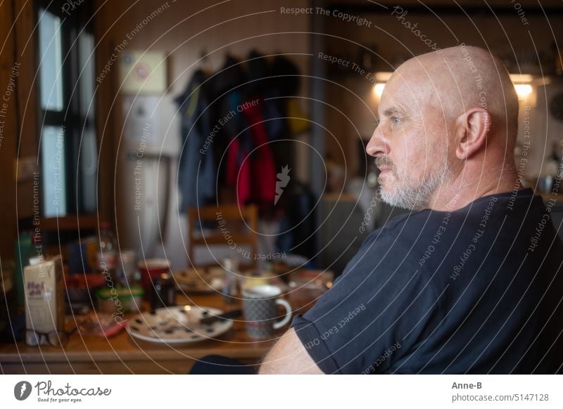 a man looks out the window after breakfast, checks the weather and plans the day's activities in comfortable quarters Breakfast Man Bald or shaved head