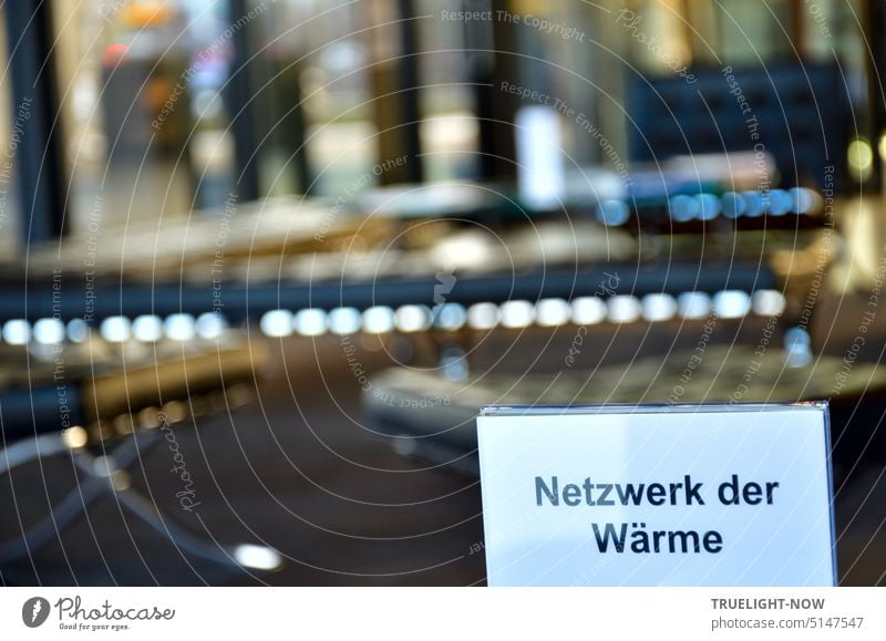 View from the luxurious seating area in the entrance area of the Neue Nationalgalerie to the entrance and outside and to a sign "Network of warmth" on the coffee table