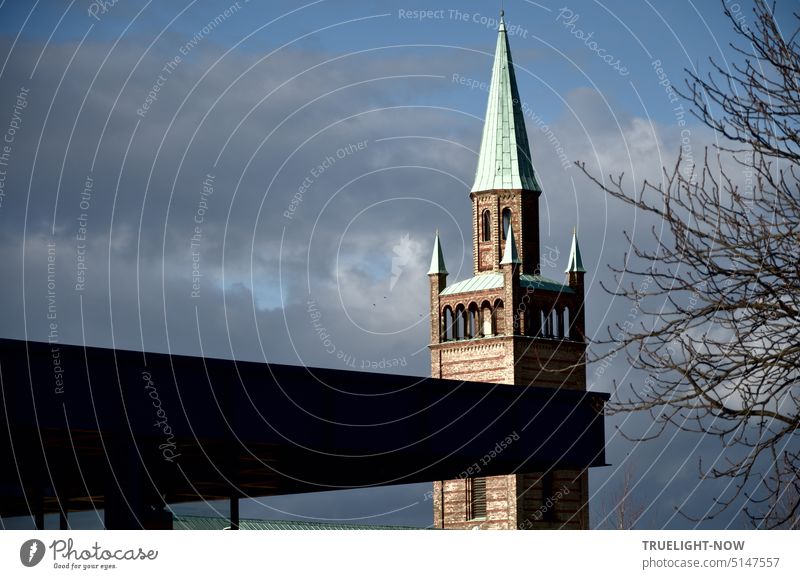 Art and church: The mighty dark steel roof of the renovated New National Gallery pushes in front of the neo-Romanesque tower of St. Matthaeus Church under a slightly cloudy wintry sky of Berlin