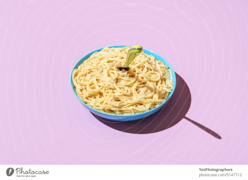 Cheese spaghetti bowl isolated on a purple background. Pasta cacio e pepe bright carbs cheese color cooked copy space creative cuisine cut out delicious dinner