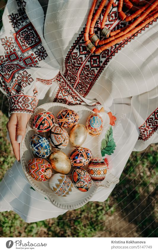 Ukrainian woman holding in hands Easter eggs. Beautiful geometric slavic decoration. Lady in embroidery vyshyvanka dress. food natural tradition traditional