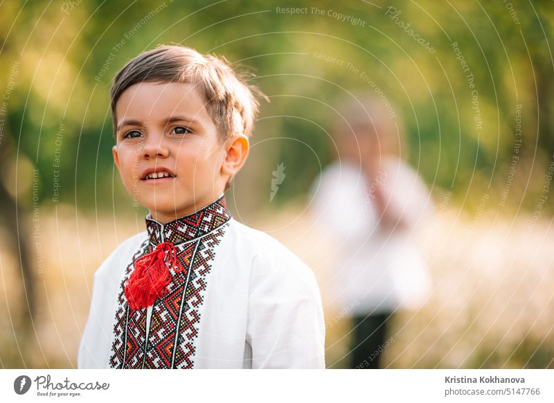 Cute portrait of little ukrainian boy in spring garden. Child in traditional embroidery vyshyvanka shirt. Ukraine, freedom, national costume, victory in war, happy childhood and future concept,